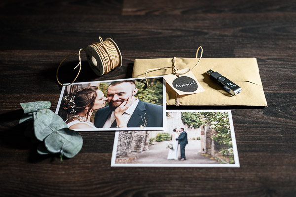 Hochzeitsfotos-mit-USB-Stick-und-Deko-auf-dunklem-Holzhintergrund