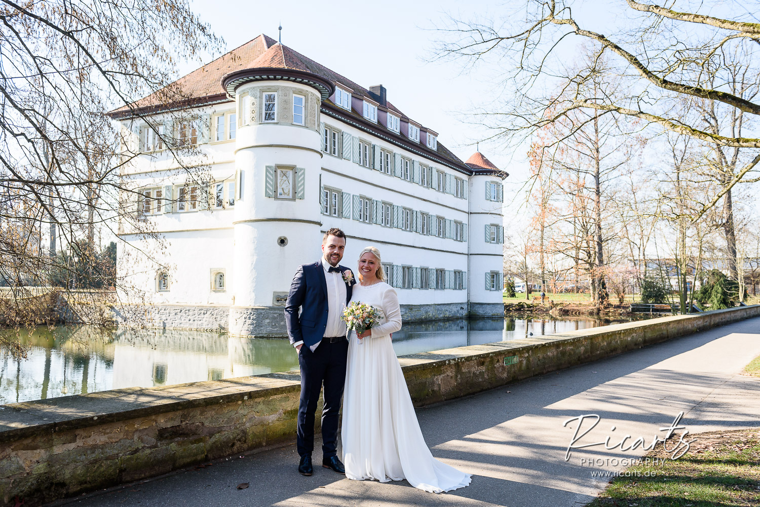 Brautpaar-steht-vor-Wasserschloss