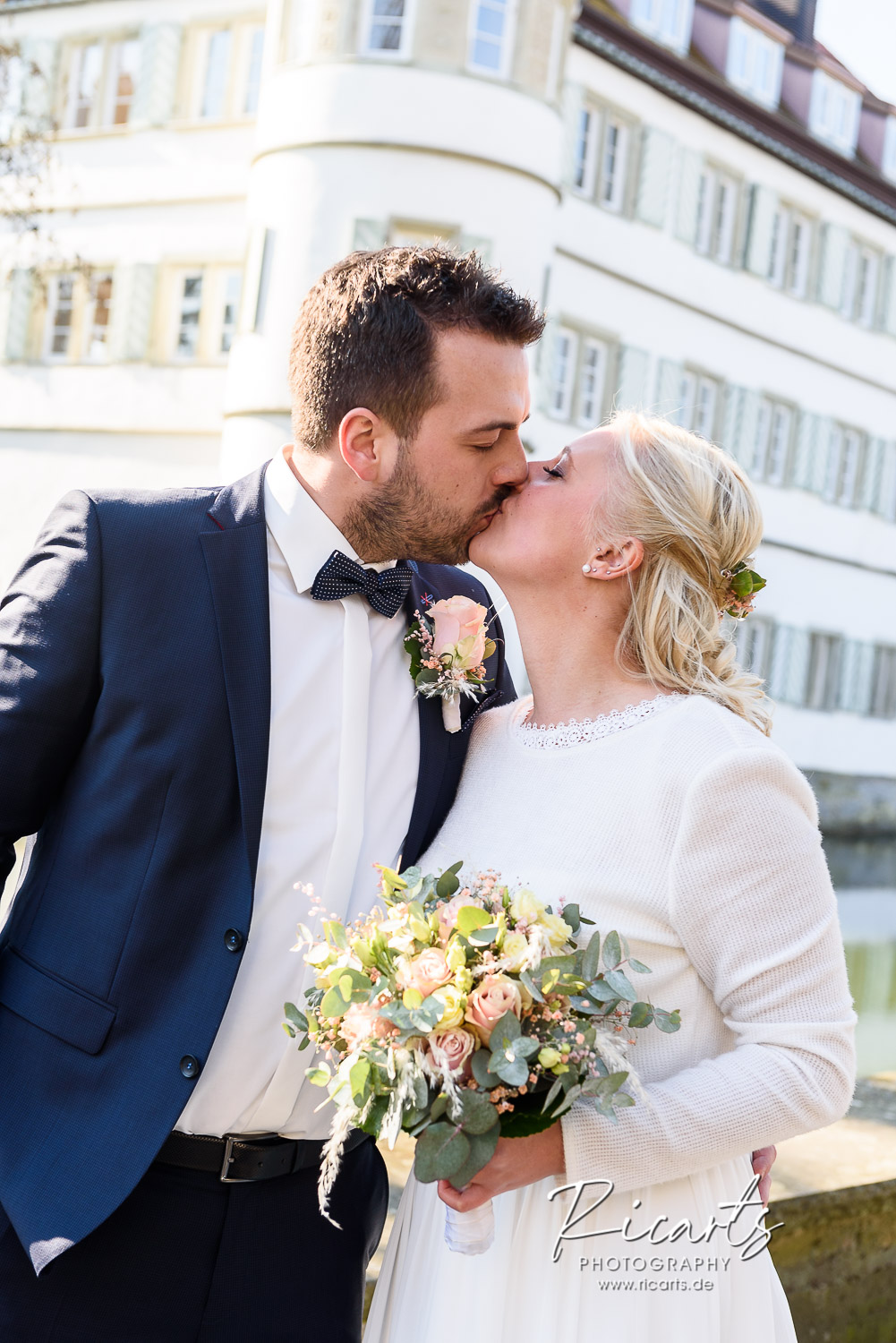 Brautpaar-küsst-sich-vor-Wasserschloss