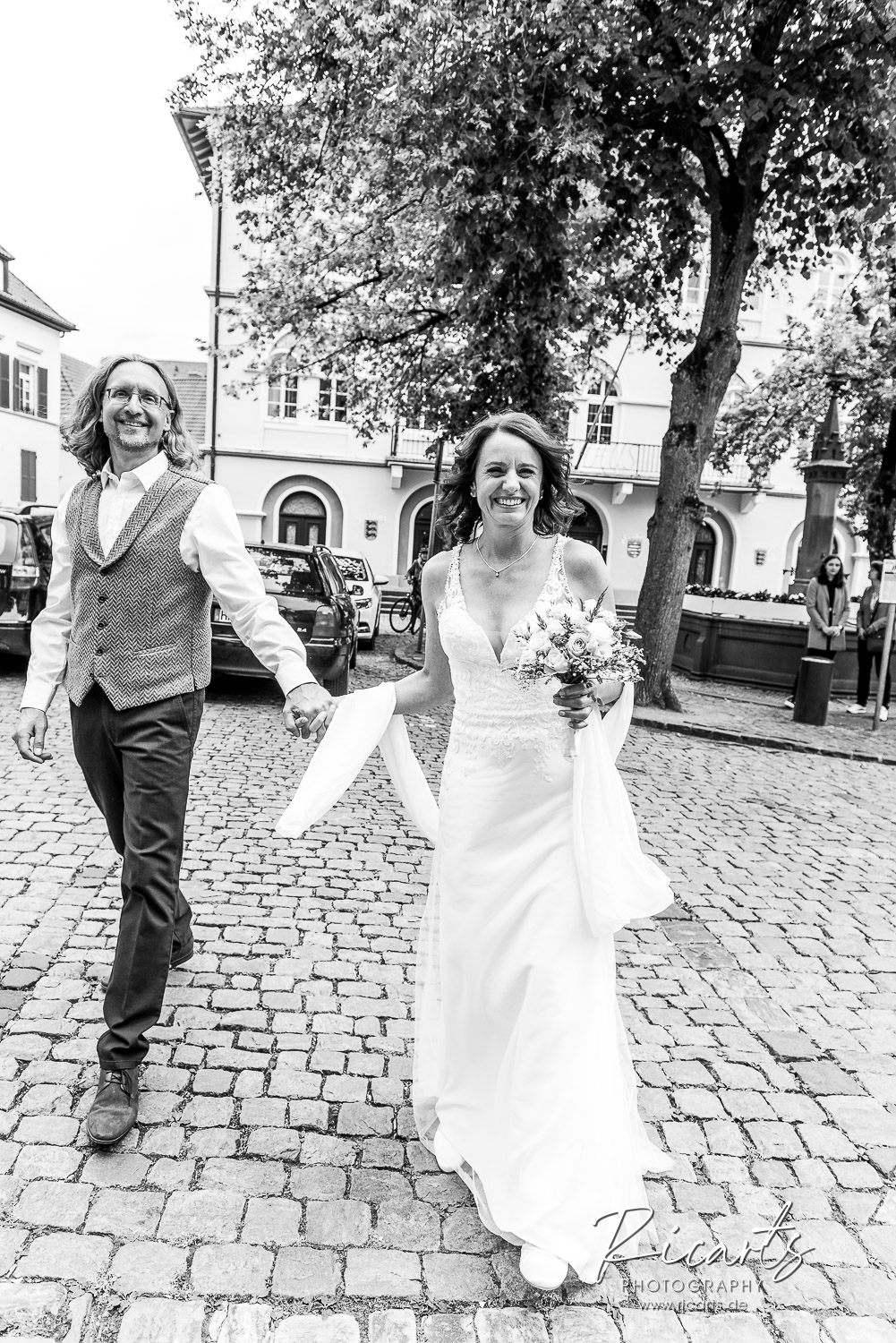 Brautpaar-geht-hand-in-hand-auf-Pflasterstein-in-Altstadt