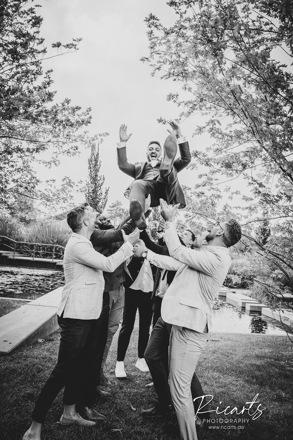 Männergruppe-wirft-Bräutigam-in-die-Luft