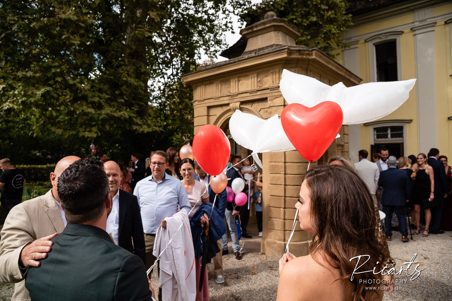 Brautpaar-mit-Luftballons-auf-Hochzeit